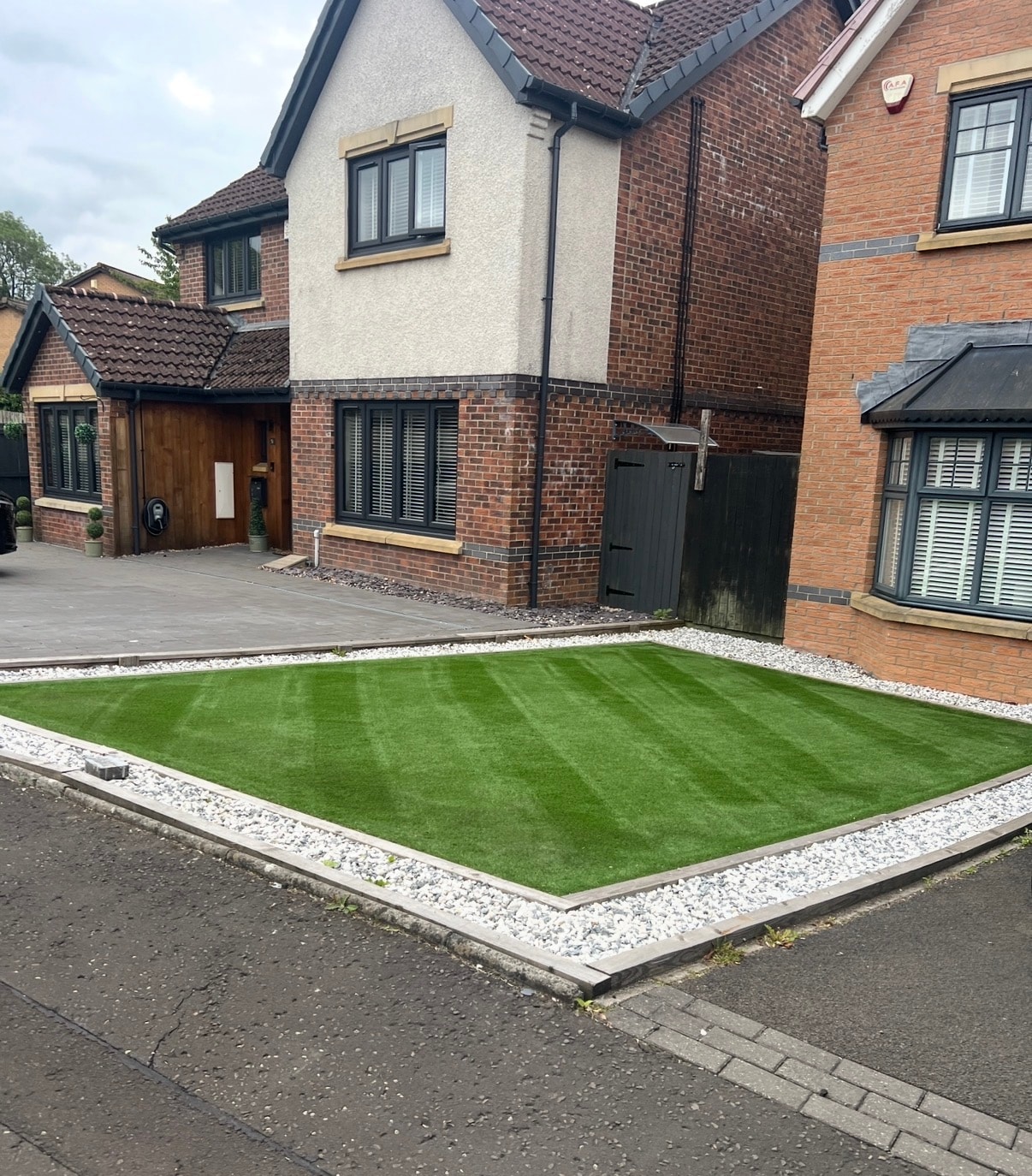 Artificial grass installation with white gravel border
