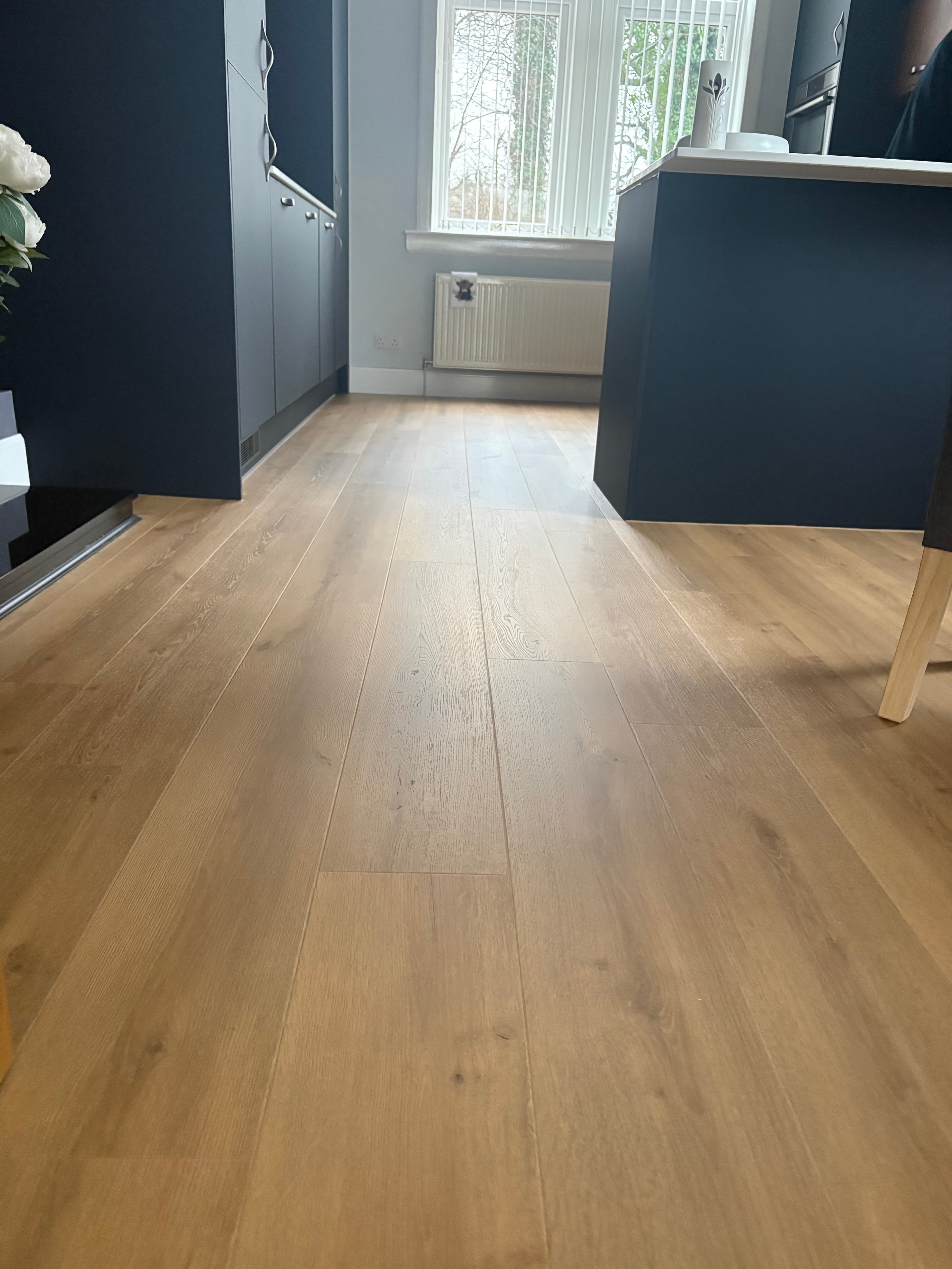 Kitchen with oak-effect hard flooring and navy cabinetry